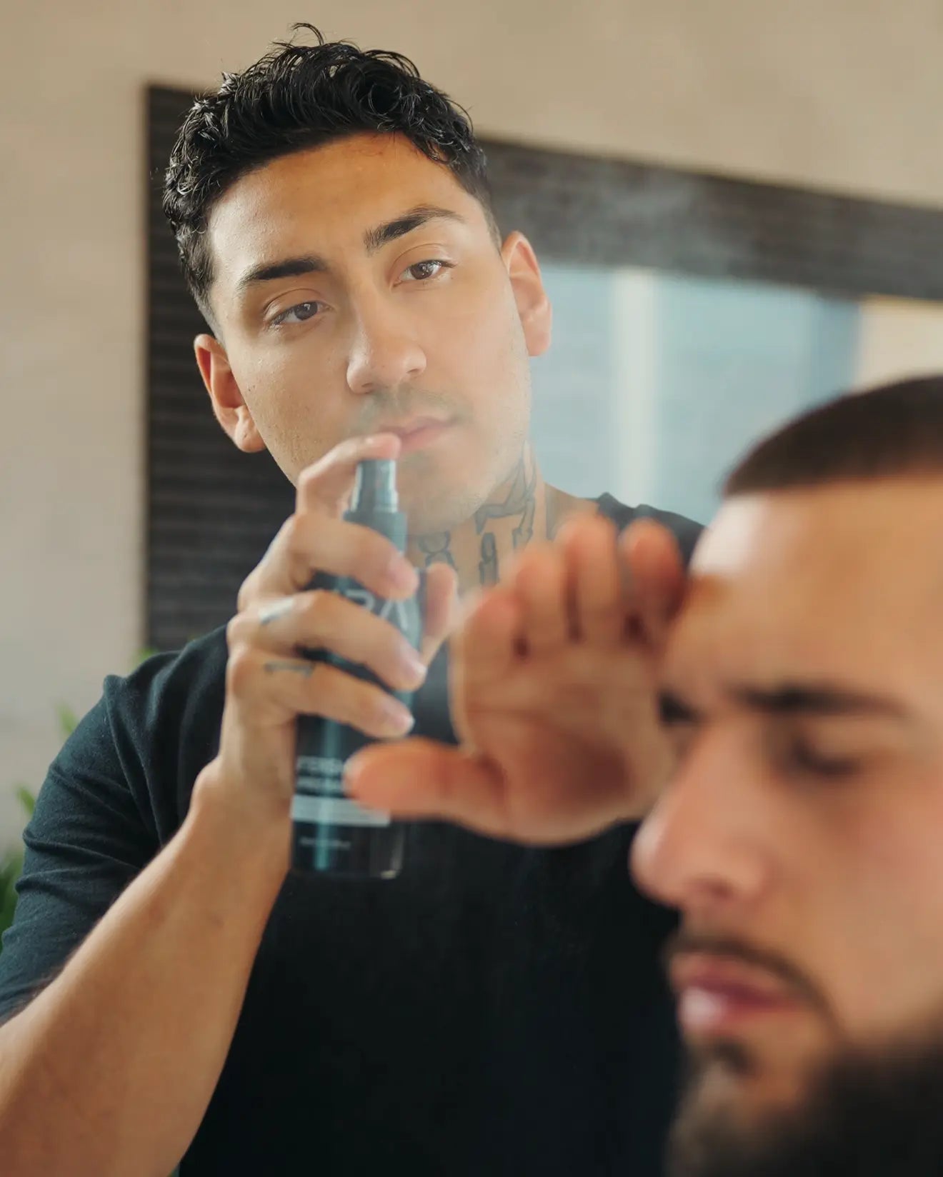 Man applying aura aftershave in front of a mirror