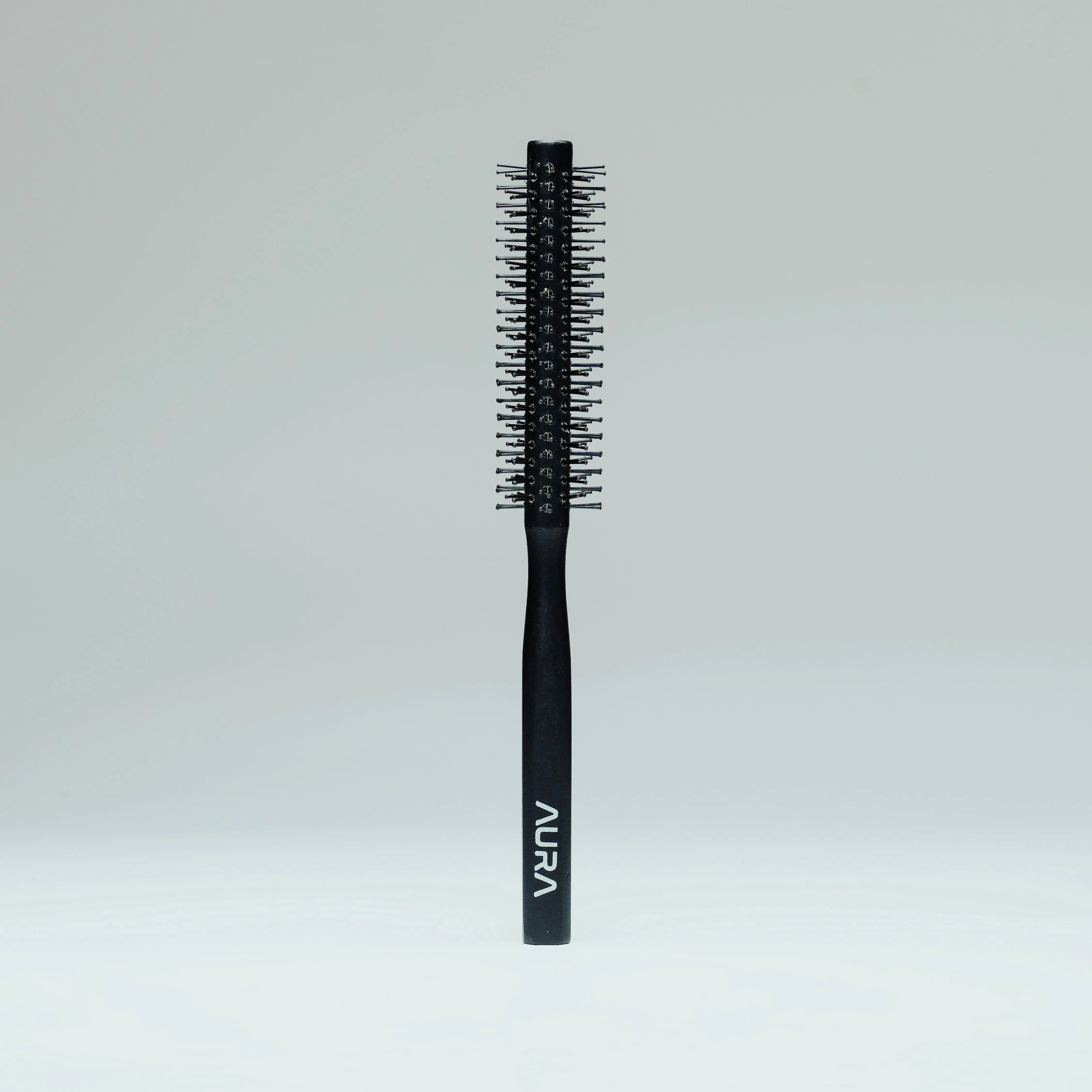 Black hairbrush with 'Aura' branding on a light gray background