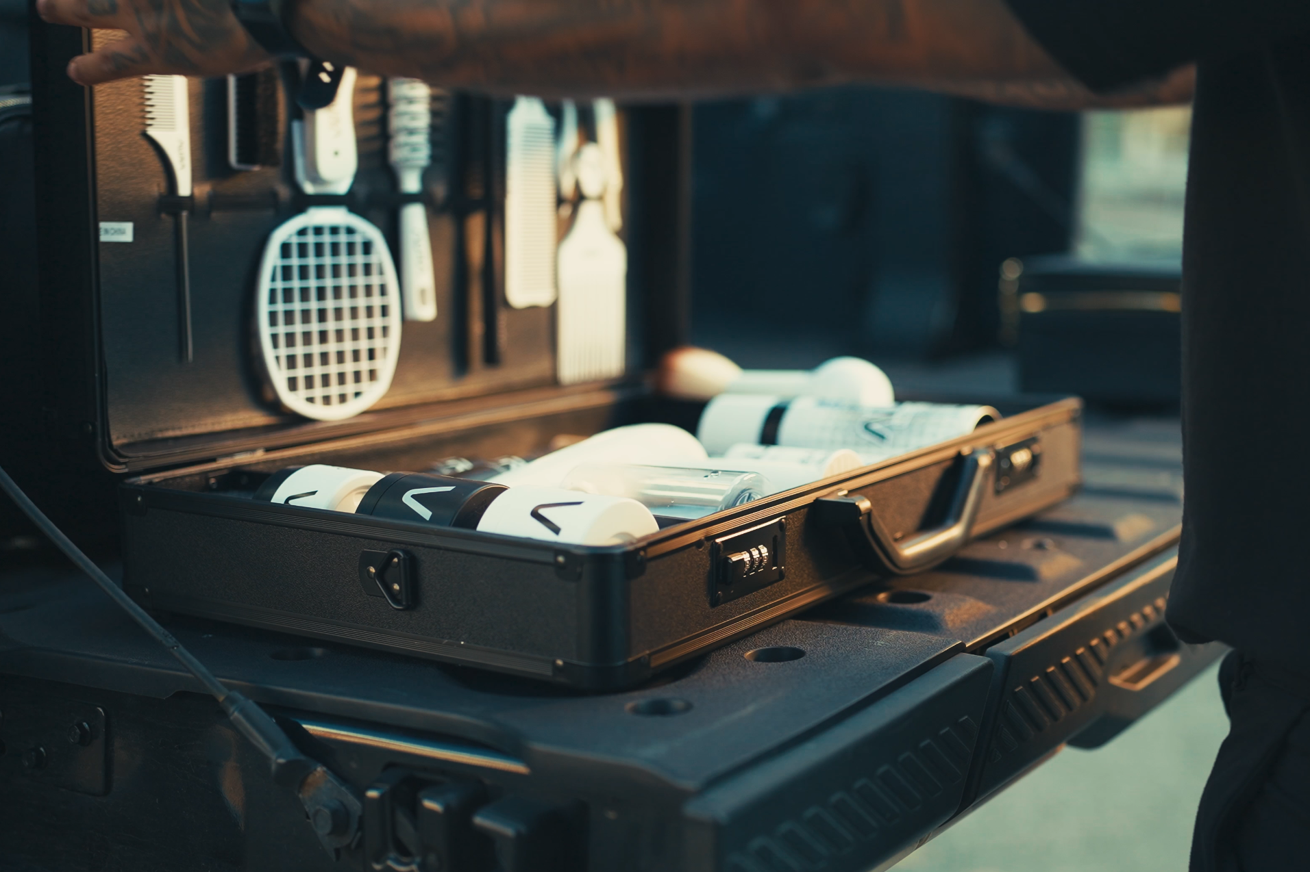 Open suitcase with  AURA toiletries on a vehicle's open trunk